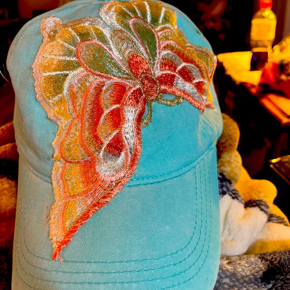 Ponytail ball cap with an embroidered butterflyy